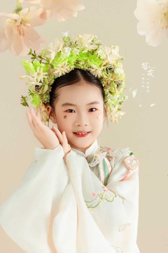 郭梦昕戴着绿色花环，托着脸微笑